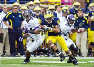 Michigan wide receiver Roy Roundtree turns to rush after making a reception. Roundtree had five catches for 139 yards.
