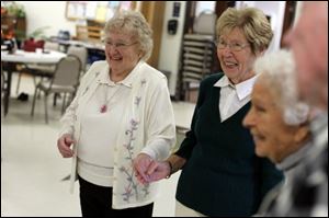 Donna Lapiarz, left, of Toledo and Gerry Braunfels, of Erie, Mi., laugh with each other about their mistakes while square dancing. 