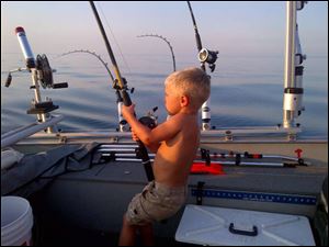 Tommy Spencer has a fish on the line during a trip on Lake Michigan. 