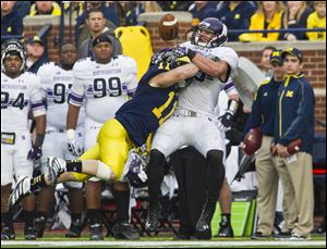 Michigan safety Jordan Kovacs (11) breaks up a pass intended for Northwestern tight end Dan Vitale.