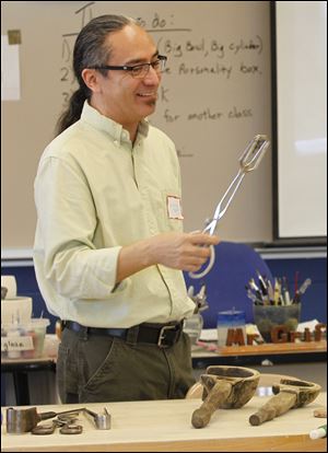 Leonard Marty, a glass maker and master instructor, shows off his glass-making tools during a session at the conference.