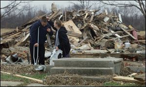 In this Blade file photo, Nick Lehmkuhle, injured in the tornado, leans on his crutches, while his sister in law, Misty Lehmkuhle looks at the lacerations on his head.