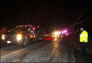 A tow truck carries a vehicle from the home on Harvest Lane where two adults and three children were found dead of carbon monoxide poisoning.