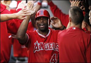 Los Angeles Angels' Torii Hunter being congratulaed in the dugout during a baseball game against the Seattle Mariners in Seattle.