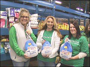 Charter One volunteers Laura Oros, Michelle Pommeranz, and Julie King load turkeys donated to the Toledo Northwestern Ohio Food Bank as part of Charter One's Carving Out Hunger program.