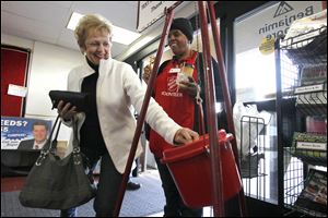 Carol Regnier donates money while volunteer Debra Vickers rings a bell during The Salvation Army's annual Red Kettle Drive kickoff at The Anderson's store in West Toledo.