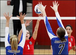 Owens Community College's sophomore setter Molly Hilfinger, center left, attempts to tip the ball past Kirkwood Community College's defenders during the first game of Thursday afternoon's match at Owens' campus in Perrysburg Township.