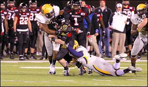 Toledo's Dwayne Harper, left, and Junior Sylvestre bring down Northern Illinois quarterback Jordan Lynch in the first half.