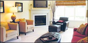 A gas fireplace with marble surround anchors the room while 10-foot ceilings tower above.