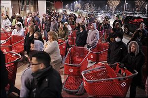 FILE- In this  Friday, Nov. 25, 2011, file photo, a crowd of shoppers wait outside the Target store in Lisbon, Conn., before the store opens for Black Friday shopping at midnight. Stores are making a big push to lure in bargain-hungry shoppers before the Friday after Thanksgiving, the traditional start of the holiday shopping season. They are putting on special sales that further creep into Turkey Day, and earlier.  (AP Photo/The Day, Sean D. Elliot, File)