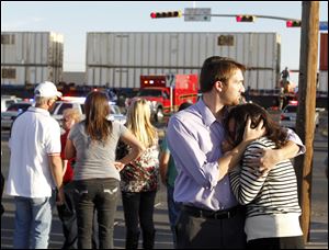 Bystanders react as emergency personnel work the scene where a trailer carrying wounded veterans in a parade was struck by a train in Midland, Texas.
