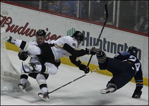 Wheeling's Cam Fergus and Peter Merth, 6,  collide with Walleye's Byron Froese during game.