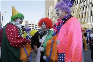 Jeff Gartz, left, Bill Carroll, and Nick Cron, members of the Distinguished Clown Corps, confer before the parade.