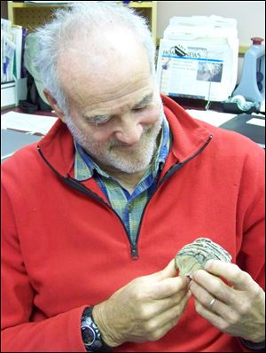 Phil Gordon displays a fragment of woolly mammoth molar Nov. 8, 2012 in Homer, Alaska that he found near Bidarka Creek. The 2011 radiocarbon dating of two remains _ an ankle bone and a tusk _ indicated woolly mammoths roamed the area between 60,000-25,000 years ago. More pieces have surfaced and been dated since then, thanks to the effort to gather these pieces together by a local author and historian. (AP Photo/Homer News, McKibben Jackinsky)