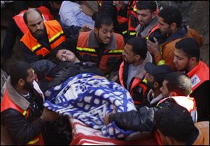 A member of the Abdel Aal family is rescued after his family house collapsed during an Israeli forces strike in the Tufah neighbourhood, Gaza City, Sunday, Nov. 18, 2012. The Israeli military widened its range of targets in the Gaza Strip on Sunday to include the media operations of the Palestinian territory's Hamas rulers, sending its aircraft to attack two buildings used by both Hamas and foreign media outlets. (AP Photo/Majed Hamdan)