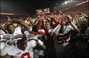 Ohio State players and coach Urban Meyer, center, sing 