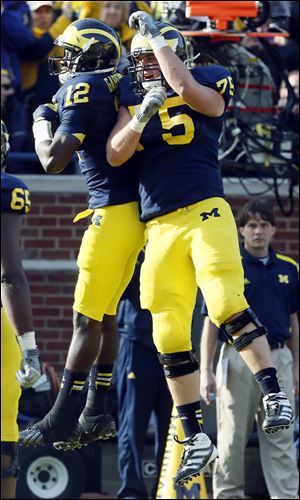 Michigan quarterback Devin Gardner, left, and Michael Schofield celebrate Gardner's touchdown run against Iowa during third quarter Saturday at Michigan Stadium in Ann Arbor. Gardner ran for three touchdowns and passed for three more in a victory.