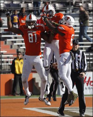 Chris Gallon, left, celebrates with Ryan Burbrink, center, and Alex Bayer after one of his two touchdowns.