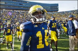 Michigan quarterback Denard Robinson walks off the field Saturday after the final home game of his career.