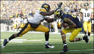 Michigan’s Roy Roundtree gets behind Iowa's Nico Law for a second-quarter score.