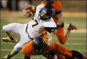 Whitmer quarterback Nick Holley is hit by Massillon Washington's  Ryan Rambo after picking up a first down.