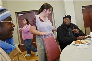 Rachael Gardner chats with Walter Anderson, Jr., 70, right, as he and Donald Spearman, 63, take part in a lunch for the homeless at Holy Trinity Greek Orthodox Cathedral community center. 