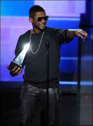 Usher accepts the award for favorite male artist in soul/R&B at the 40th Annual American Music Awards on Sunday in Los Angeles.