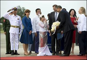 President Obama is presented with flowers after he and Secretary of State Hillary Clinton, far right, arrive at Yangon International Airport in Yangon, Myanmar, today. Mr. Obama is touring Southeast Asia.