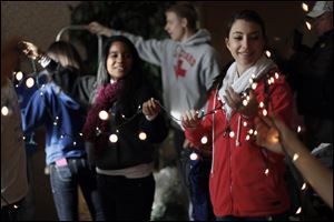 Rachel Helminiak, right, a senior at Springfield High School, helps untangle a strand of lights with her fellow volunteers of Students in Action at Luthern Village in Holland.
