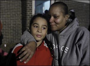Nicholas M. Lopez, 9, and his mother, Markeda Holcomb-Brownlee, mourn the loss of murder victim CreJonnia Bell, 19, during her vigil at her mother's apartment at the Moody Manor in Toledo. Bell was Nicholas' sister and KeeKee's daughter.