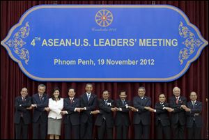 President Obama, fifth from left, stands hand in hand with ASEAN leaders for a family photo during the ASEAN-U.S. leaders' meeting at the Peace Palace in Phnom Penh, Cambodia, Monday. They are, from left: Philippines' President Benigno Aquino III, Singapore's Prime Minister Lee Hsien Loong, Thailand's Prime Minister Yingluck Shinawatra, Vietnam's Prime Minister Nguyen Tan Dung, Mr. Obama, Cambodia's Prime Minister Hun Sen, Brunei's Sultan Hassanal Bolkiah, Indonesia's President Susilo Bambang Yudhoyono, Laos Prime Minister Thongsing Thammavong, Malaysia's Prime Minister Najib Razak and Myanmar's President Thein Sein. 
