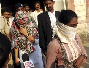 Face covered Shaheen Dhada, left, and Renu Srinivas, Indian women arrested for their Facebook posts, come out of a court in Mumbai, India, today.