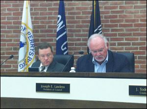 Council president Joseph Lawless, right, reads minutes from the recreation committee at Tuesday's city council meeting as clerk David Creps looks on. 
