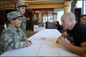 Lukas Nieto, 4, and his brother Zeke Kniffen, 10, get autographs from mixed martial arts fighters including 2004 Olym­pian Devin Var­gas, a Start High School grad­u­ate who is now a pro­fes­sional boxer.