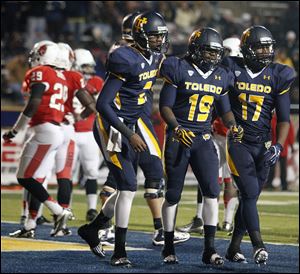 University of Toledo RB Cassius McDowell (19) celebrates scoring a touchdown with Terrance Owens (2) and Dwight Malcolm (17)  against Ball State Tuesday, 11/06/12, at the Glass Bowl in Toledo.