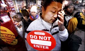Frankie Lee, the first in a line of several hundred shoppers at a Wal-Mart  in Oakland, Calif., rubs his eyes shortly before the store opens at 5 a.m. in November, 2008.