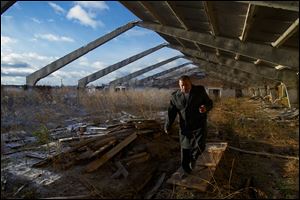 Eduard Mochalov, editor of The Bribe, walks through a derelict hog barn on his abandoned farm in Yarabaikasy near Cheboksary, the capital city of Chuvashia, Russia. 