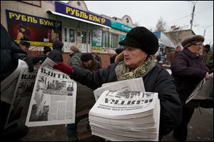 A woman hands out copies of  Eduard Mochalov's newspaper Bribe in Cheboksary, the capital city of Chuvashia, Russia.