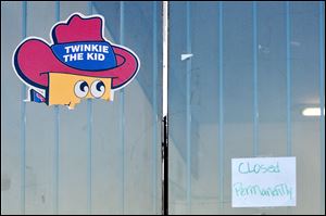 A 'closed permanently' sign joins a Twinkie The Kid poster on the Wonder Hostess Bakery Outlet store in Victorville, Calif. The store closed Saturday.
