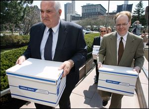 Andy Stuart, right, and Tom Schlachter carry boxes of petitions into Government Center in 2009 as part of an effort to recall then-Mayor Carty Finkbeiner. 