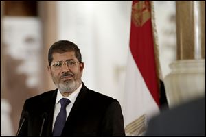 Egyptian President Mohammed Morsi, right, swears in his new Prosecutor General, Talaat Abdullah, left, in Cairo, Egypt, Thursday. Egypt's president on Thursday issued constitutional amendments granting himself far-reaching powers and ordering the retrial of leaders of Hosni Mubarak's regime for the killing of protesters in last year's uprising. Morsi also on Thursday fired the country's top prosecutor by decreeing with immediate effect that he could only stay in office for four years and replacing him with Talaat Abdullah. Morsi fired Abdel-Maguid Mahmoud for the first time in October, but had to rescind his decision when he found that the powers of his office do not empower him to do so. 