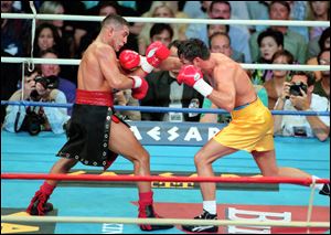 Hector Camacho, left, fights Oscar De La Hoya in a boxing match at Thomas and Mack Center in Las Vegas. Camacho's family tried to decide Wednesday, whether he should be removed from life support after a shooting in his Puerto Rican hometown left the former boxing champion clinging to life and his fans mourning the loss of a dynamic and often troubled athlete.
