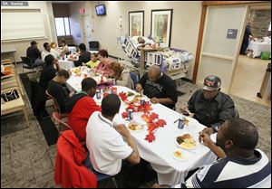 Anthony Taylor, in his hospital bed, and his family gather for their Thanksgiving Day meal at the University of Toledo Medical Center.