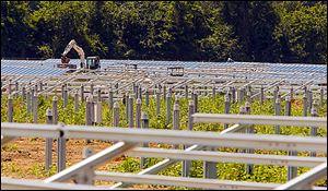 Workers install the structures which will hold solar panels on a farm in St. Paul, N.C. Land owners in rural eastern North Carolina are leasing out there land to solar companies.