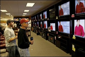 Mike DeBrosse, right, of Maumee checks out the Black Friday deals on televisions at the Appliance Center Home Store in Maumee.