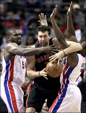 Toronto Raptors forward Andrea Bargnani, center, is pressured by Detroit Pistons forward Jason Maxiell (54) and guard Brandon Knight (7).