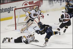 Toledo's center Joey Martin's (14) shot on goal is rebuffed by Cincinnati's goal tender Brian Foster during the second period of Friday night's game in Toledo. At the end of the second period, the Cyclones led the Walleye, 3-0.