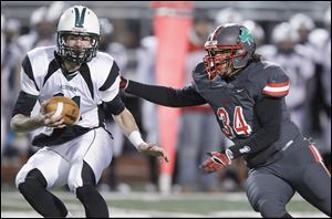 Aurora High School quarterback George Bollas, 11, eludes Central Catholic player Ian Butler, 34.