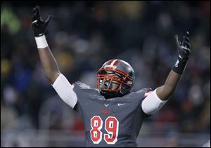 Central Catholic player Keith Towbridge celebrates after the Irish defeat Aurora High School 20-13 during their Division II state semi-final game at Huron High School.