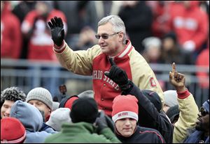 Former Ohio State coach Jim Tressel is carried on the shoulders of his 2002 national championship team after being honored at the game.